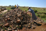 Jane Places Weapon on Rock Pile